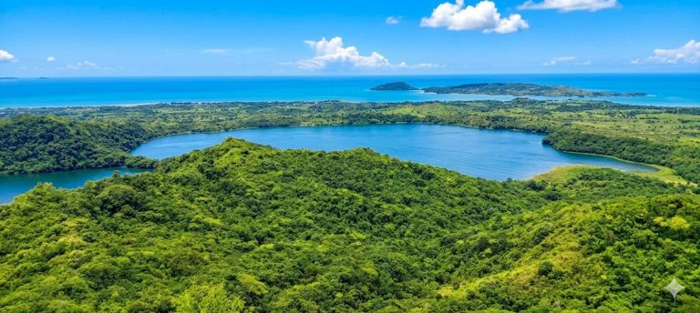 Vue panoramique sur les lacs volcaniques et l’océan depuis le Mont Passot à Nosy Be Caption Description