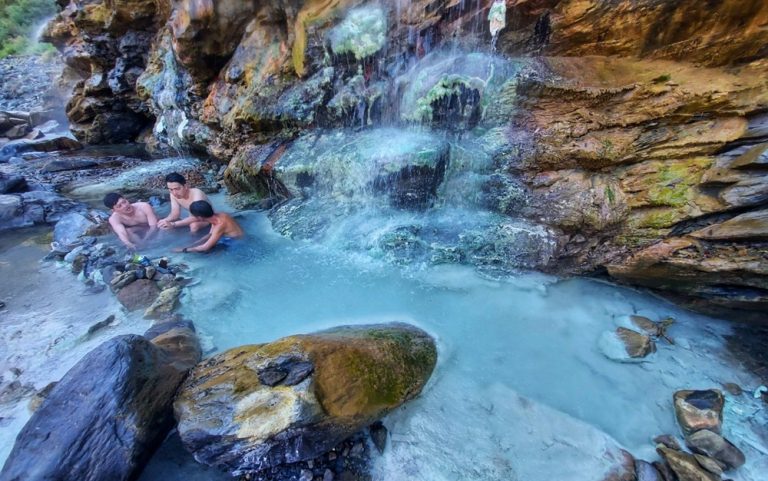 Taiwan hot springs in a rocky mountain gorge with natural geothermal pools, cascading mineral water, and outdoor bathing scenery