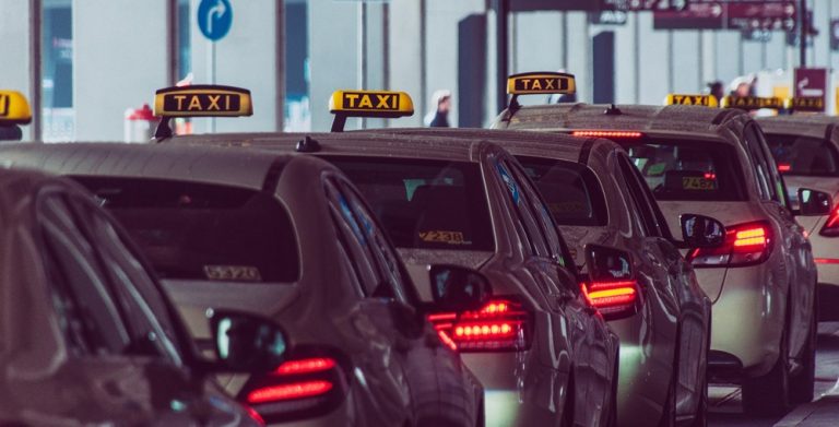 Line of airport taxis waiting outside the passenger terminal pickup zone