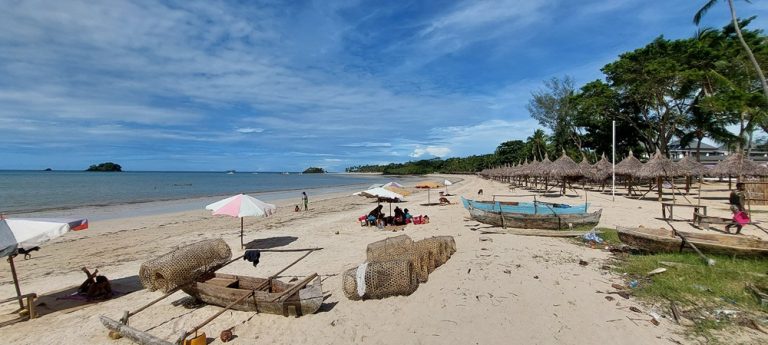 Plages de Madagascar à Andilana Beach sur Nosy Be avec sable blanc, pirogues traditionnelles et eaux calmes Légende Description
