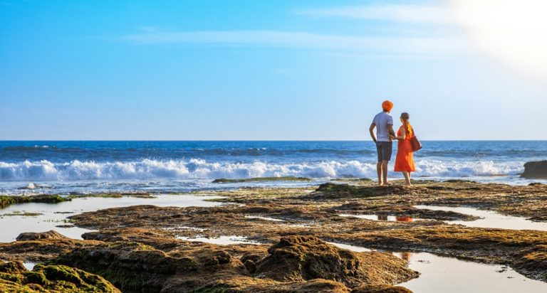 Couple enjoying a romantic coastal walk during a Bali honeymoon - Bali honeymoon guide