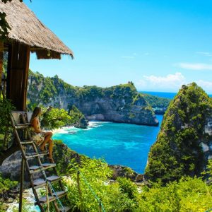 Bali packing list traveler overlooking Nusa Penida coastline and turquoise ocean in Bali Indonesia