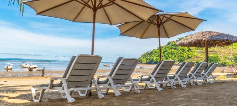 Hôtel-Résidence Au Sable Blanc à Nosy Be avec transats sur la plage et vue sur la baie de Madagascar