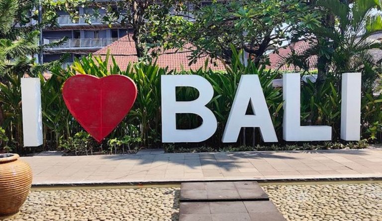 Visitors posing beside an I Love Bali sign in Seminyak, Bali