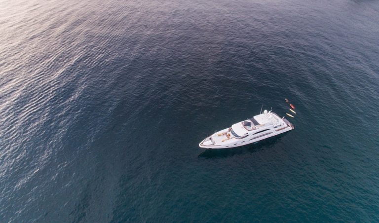 Luxury yacht anchored off the coast in this Nusa Penida travel guide, showcasing private boat tours, snorkeling trips, and island excursions