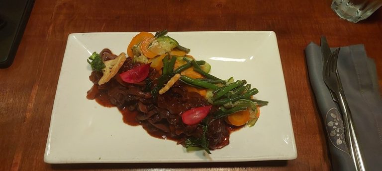 Que manger à Madagascar : plat de viande mijotée accompagné de légumes frais dans un restaurant malgache Caption : Description :