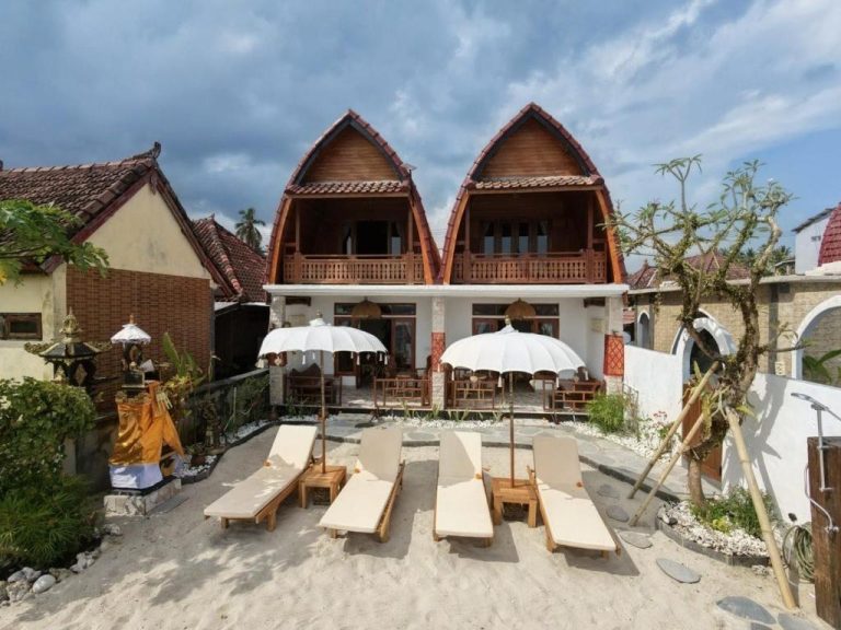 Sandy Beach Villas in Toyapakeh, Nusa Penida, featuring traditional wooden villas, a beachfront terrace, and sun loungers