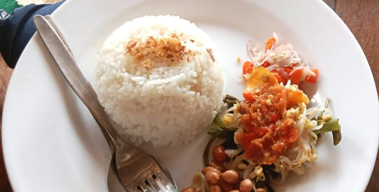 Food in Bali featuring steamed rice, sambal, vegetables, peanuts, and traditional Balinese side dishes served at a local warung