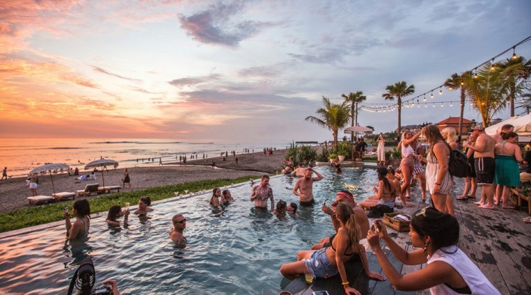 Beachfront pool and sunset atmosphere at The Lawn Canggu overlooking Bali's southwest coastline