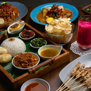 Food in Bali featuring traditional Balinese dishes, rice, satay, noodles, sambal, crackers, and tropical drinks