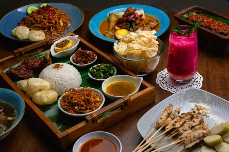 Food in Bali featuring traditional Balinese dishes, rice, satay, noodles, sambal, crackers, and tropical drinks