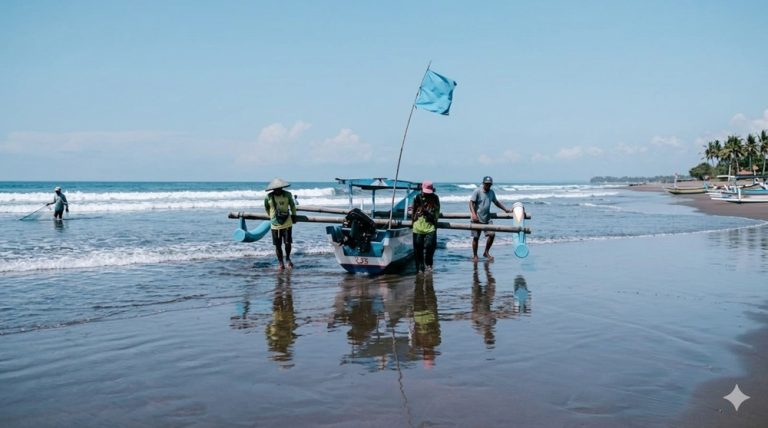 Local fishermen launching a traditional fishing boat from a sandy beach on Bali's coastline