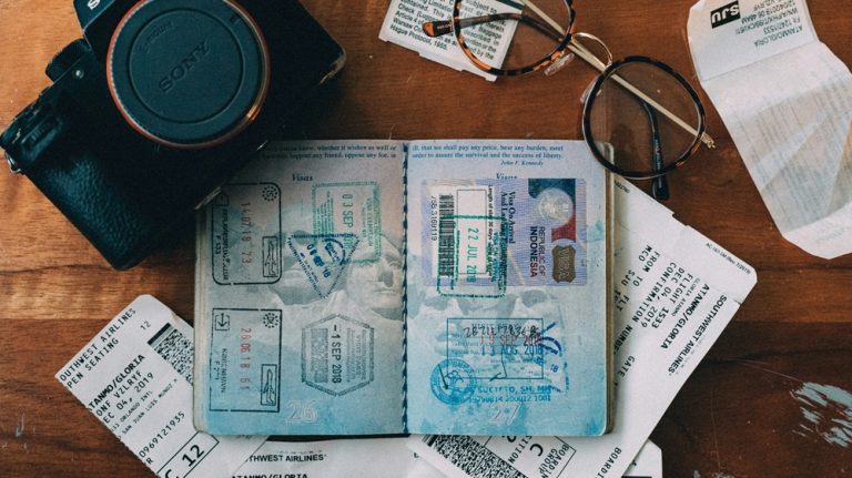 Passport with visa stamps boarding passes travel documents camera and glasses prepared for international travel