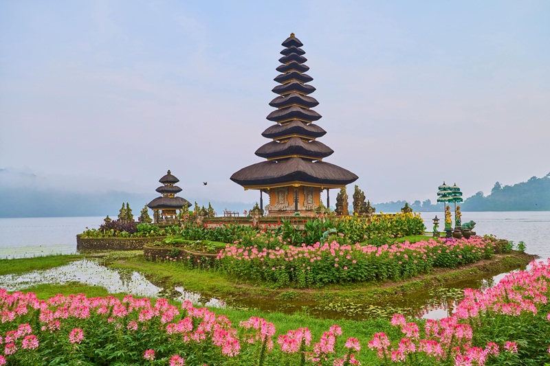 Best areas to stay in Bali guide featuring Ulun Danu Beratan Temple on Lake Beratan surrounded by colorful flowers