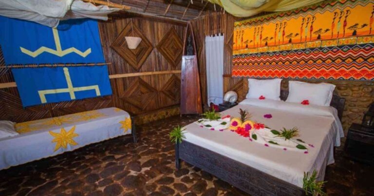 Chambre traditionnelle du Zahir de l'Île à Nosy Iranja avec lit double, décoration malgache et moustiquaire