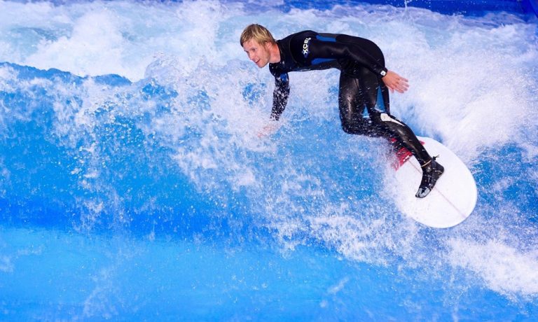 Experienced surfer riding a powerful breaking wave in Bali, featured in this Bali surf guide.