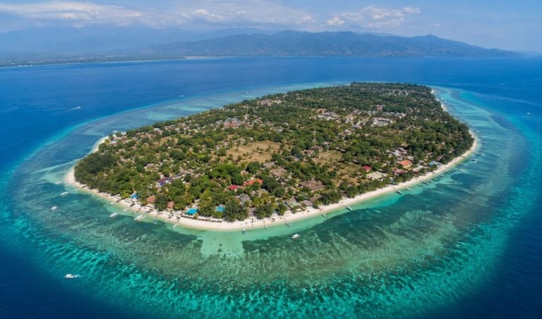 Aerial view of Gili Air surrounded by turquoise coral reefs, white-sand beaches and the crystal-clear waters of the Lombok Strait.