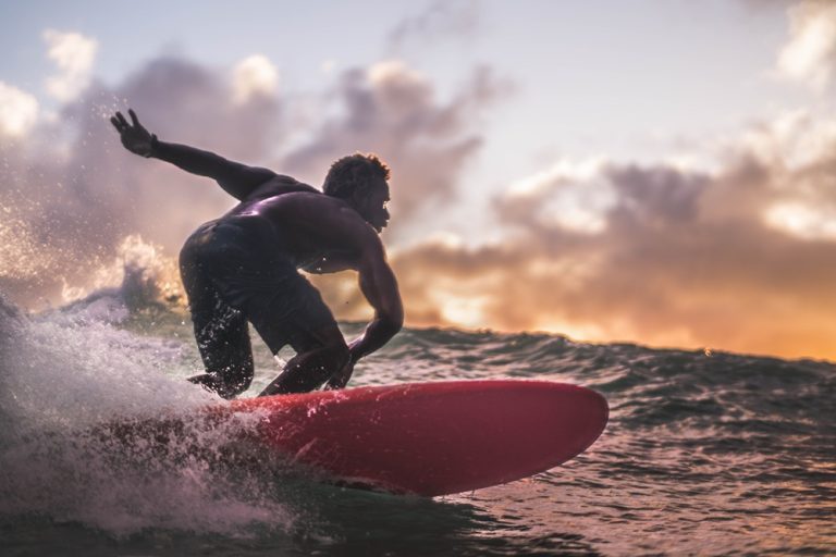 Surfer carving across a wave at sunset in Bali, featured in this Bali surf guide.