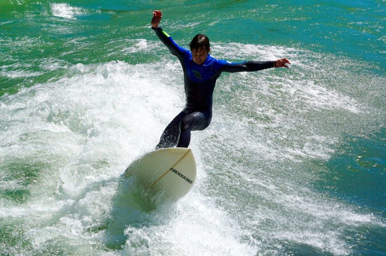 Experienced surfer carving through a breaking wave in Bali, featured in this Bali surf guide.