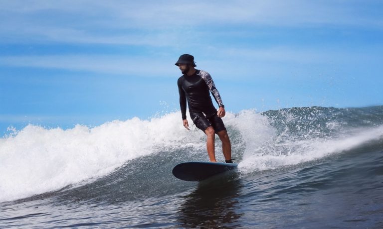 Surfer riding a long left-hand wave at Medewi in Bali, featured in this Bali surf guide.