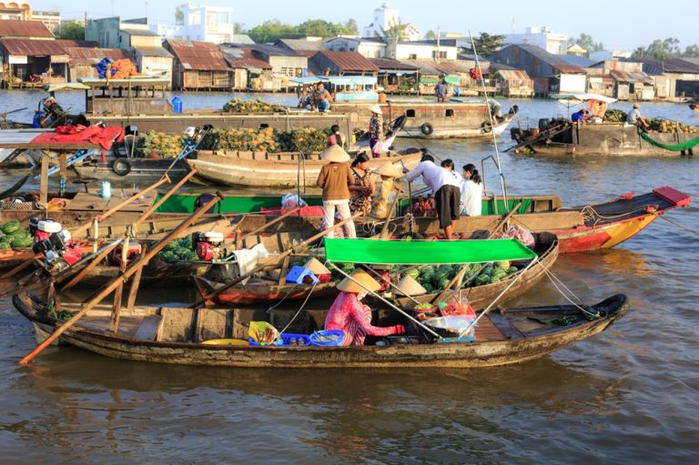 Traditional boats trading fresh fruit and vegetables at Cái Răng Floating Market in the Mekong Delta, Vietnam Caption Description