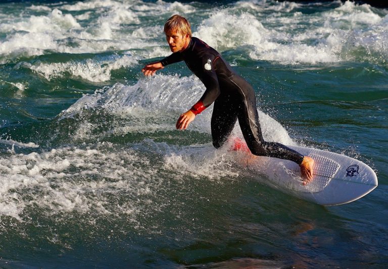Experienced surfer carving across a clean wave in Bali, featured in this Bali surf guide. Caption Description