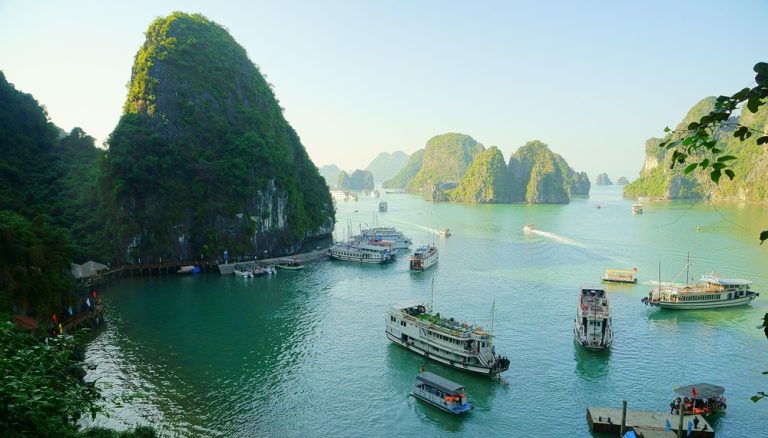 Cruise boats sailing through Ha Long Bay, one of the best things to do in Vietnam and a UNESCO World Heritage Site