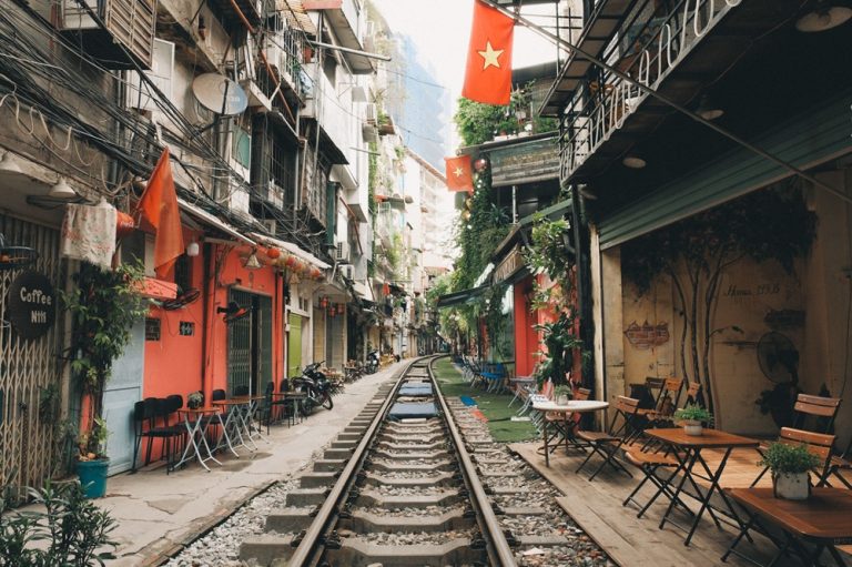 Hanoi Train Street lined with cafés, railway tracks and Vietnamese flags in the heart of Hanoi, Vietnam