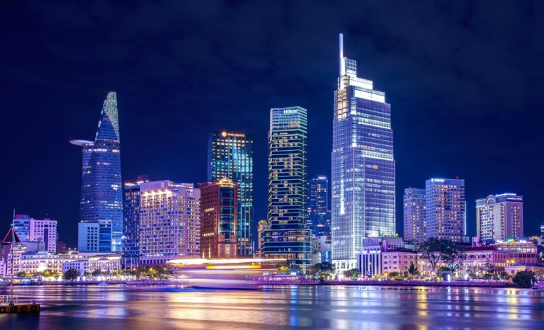 Ho Chi Minh City skyline illuminated at night with modern skyscrapers reflected in the Saigon River, Vietnam Caption Description