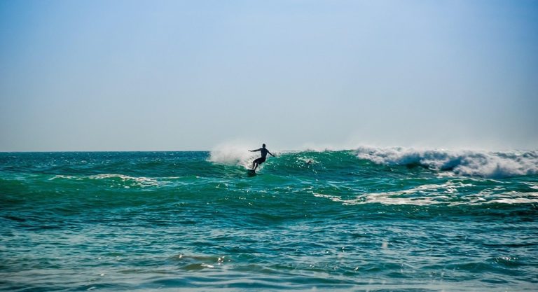 Kuta Lombok Travel Guide: Surfer riding a turquoise wave in Indonesia, showcasing the country's world-class surf conditions. Caption Description