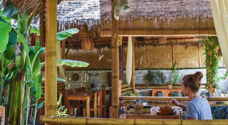 Open-air bamboo restaurant at Mad Monkey Gili Trawangan with tropical décor, wooden furnishings and a relaxed island atmosphere.