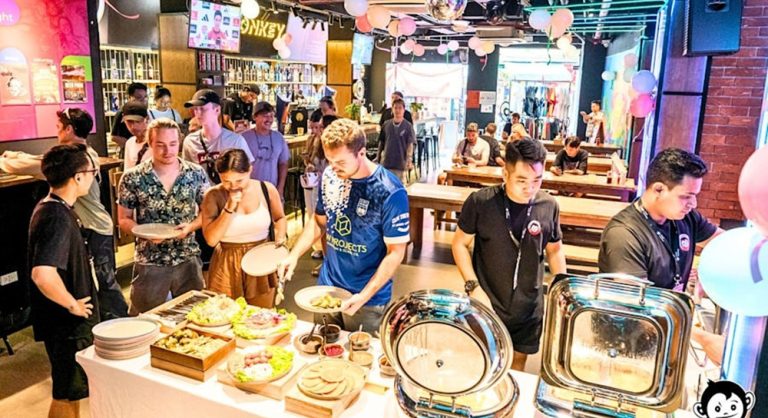 Backpackers enjoying the social area and buffet at Mad Monkey Hostel Hanoi, Vietnam.