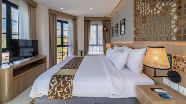 Modern guest room at Montana Oceanside Mandalika in Kuta Lombok with king-size bed, contemporary décor and large windows. Caption Description
