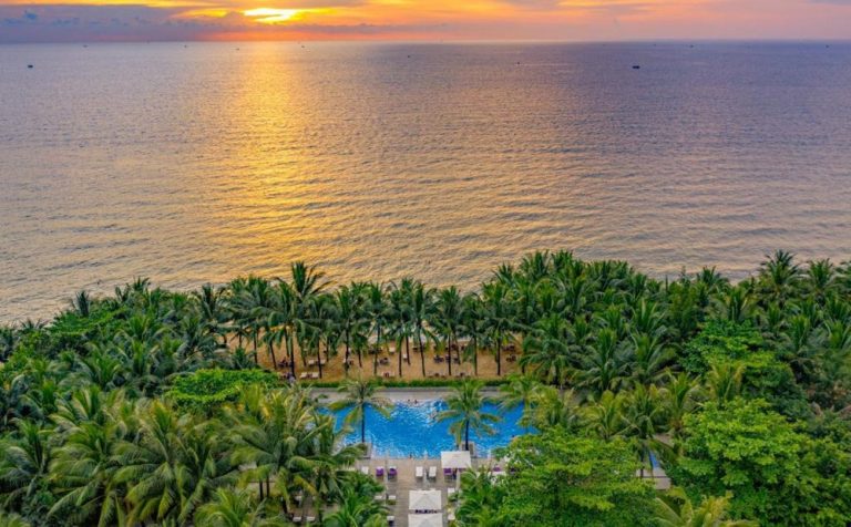 Aerial view of Salinda Resort Phu Quoc Island overlooking the beach and the Gulf of Thailand at sunset.