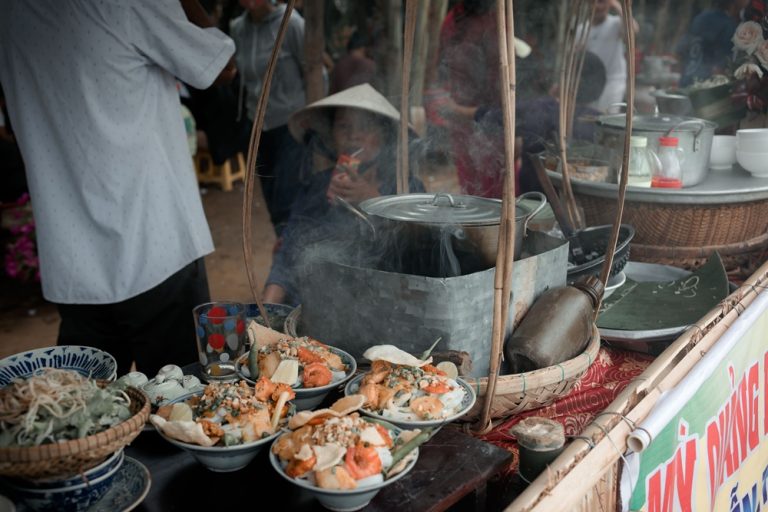 Traditional Vietnamese street food stall serving freshly prepared local dishes at a busy market