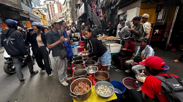 Street food vendors serving local meals in a busy market street in Antananarivo, Madagascar