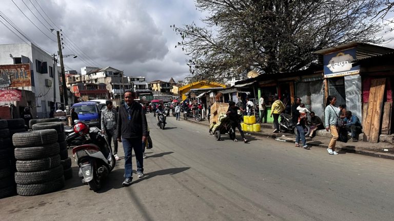 Busy street in Antananarivo, Madagascar, with pedestrians, motorbikes, local shops and street-side businesses Caption: Description:
