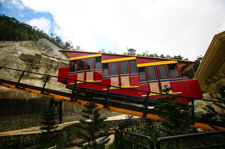 Red and yellow funicular railway climbing the mountainside at Ba Na Hills near Da Nang Caption: Description: