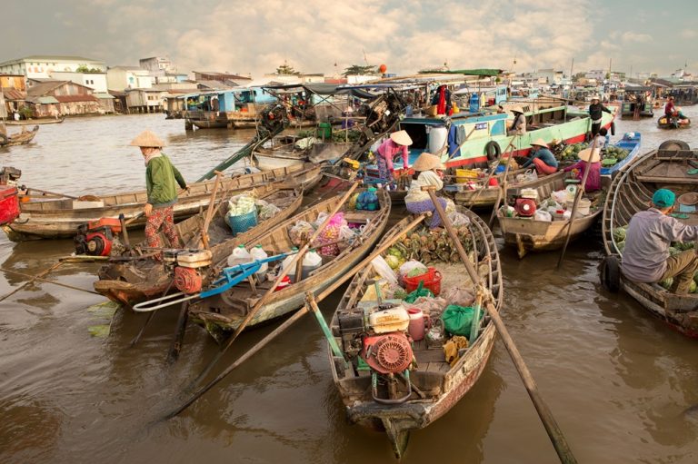 Traditional boats trading fruit and vegetables at Cai Rang Floating Market in the Mekong Delta
