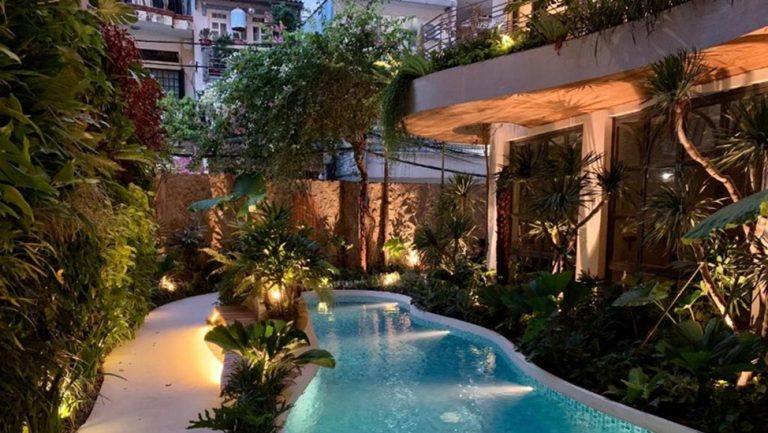 Swimming pool surrounded by tropical gardens at CityHouse VIBE City Oasis in Ho Chi Minh City