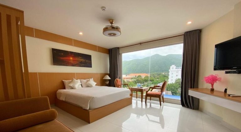 Spacious room at Conson Hotel in Con Dao with a king-size bed, large picture window and mountain views.