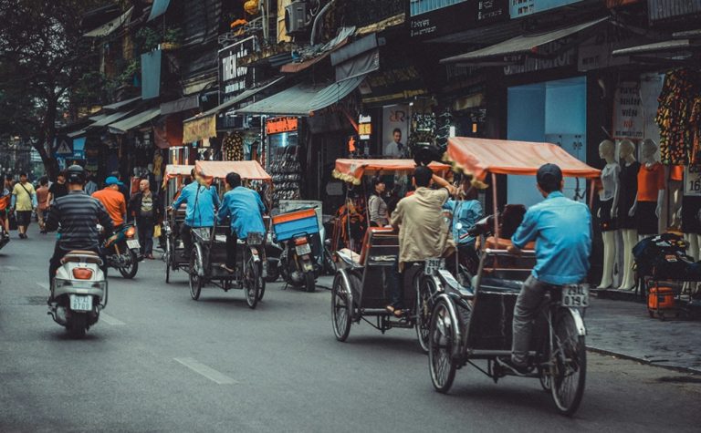 Traditional cyclos transporting visitors through the lively streets of Hanoi's Old Quarter in Vietnam