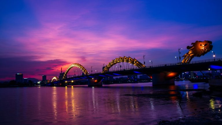 The illuminated Dragon Bridge crossing the Han River at sunset in Da Nang Vietnam