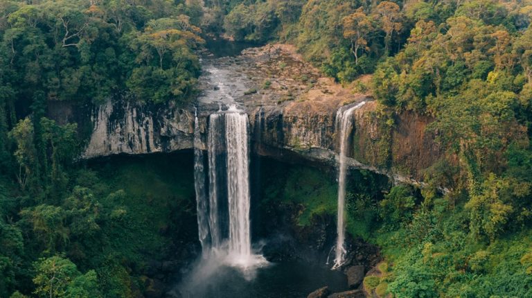 Elephant Waterfalls surrounded by lush forest, showcasing Vietnam's spectacular natural landscapes and outdoor adventures.