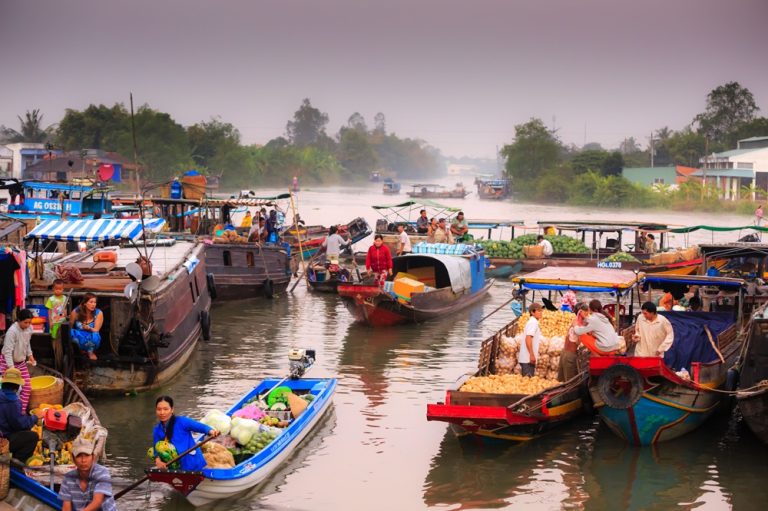 Getting around Vietnam by boat at a bustling floating market in the Mekong Delta