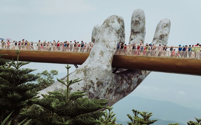 Visitors walking across the iconic Golden Bridge at Ba Na Hills near Da Nang, Vietnam