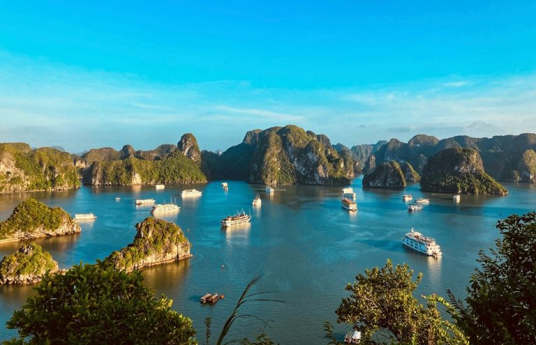 Cruise boats sailing among the limestone islands of Ha Long Bay Caption Description