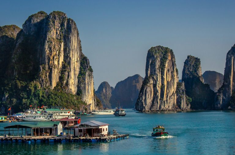 Floating fishing village surrounded by towering limestone islands in Ha Long Bay