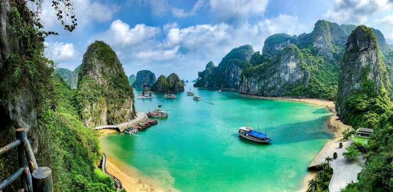 Panoramic view of Ha Long Bay with emerald waters, limestone karsts and traditional cruise boats in Northern Vietnam