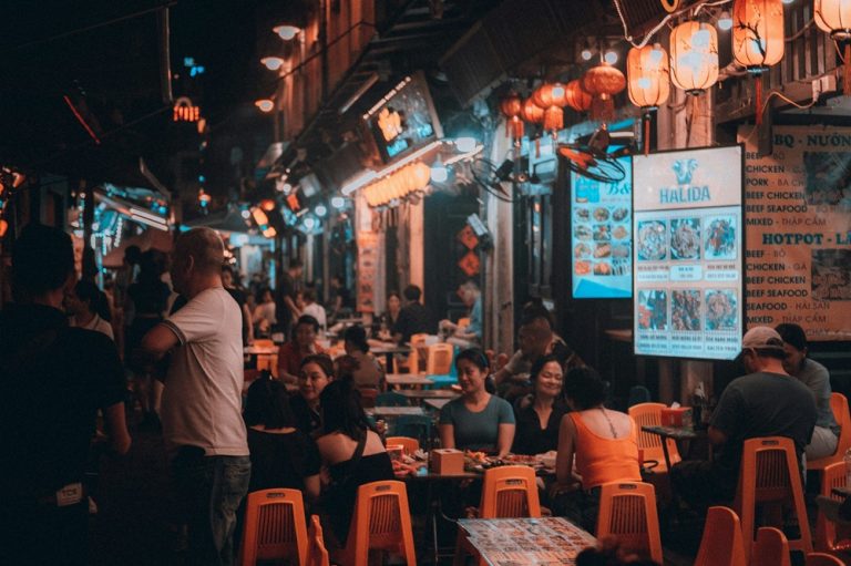 Busy Hanoi street at night with diners, restaurants and glowing lanterns
